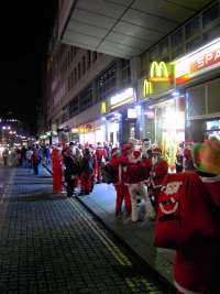 Weihnachtsmaenner vor McDonalds und Spar
